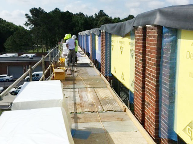 virginia-based croy contracting inc. working on commercial construction job at cox cable workers on scaffolding doing exterior work